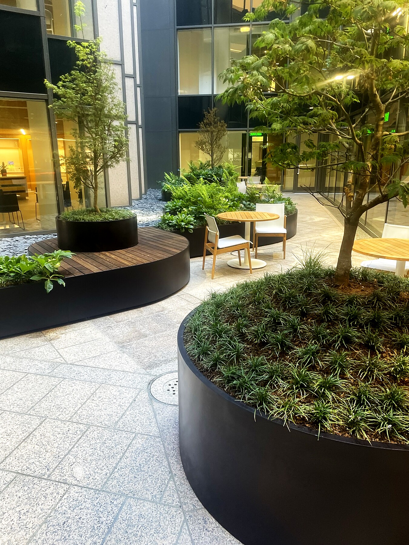 Custom curved steel planter bench in a corporate courtyard